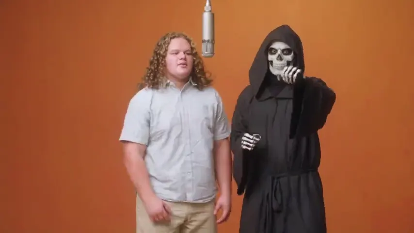 A young man and a grim reaper sharing the mic